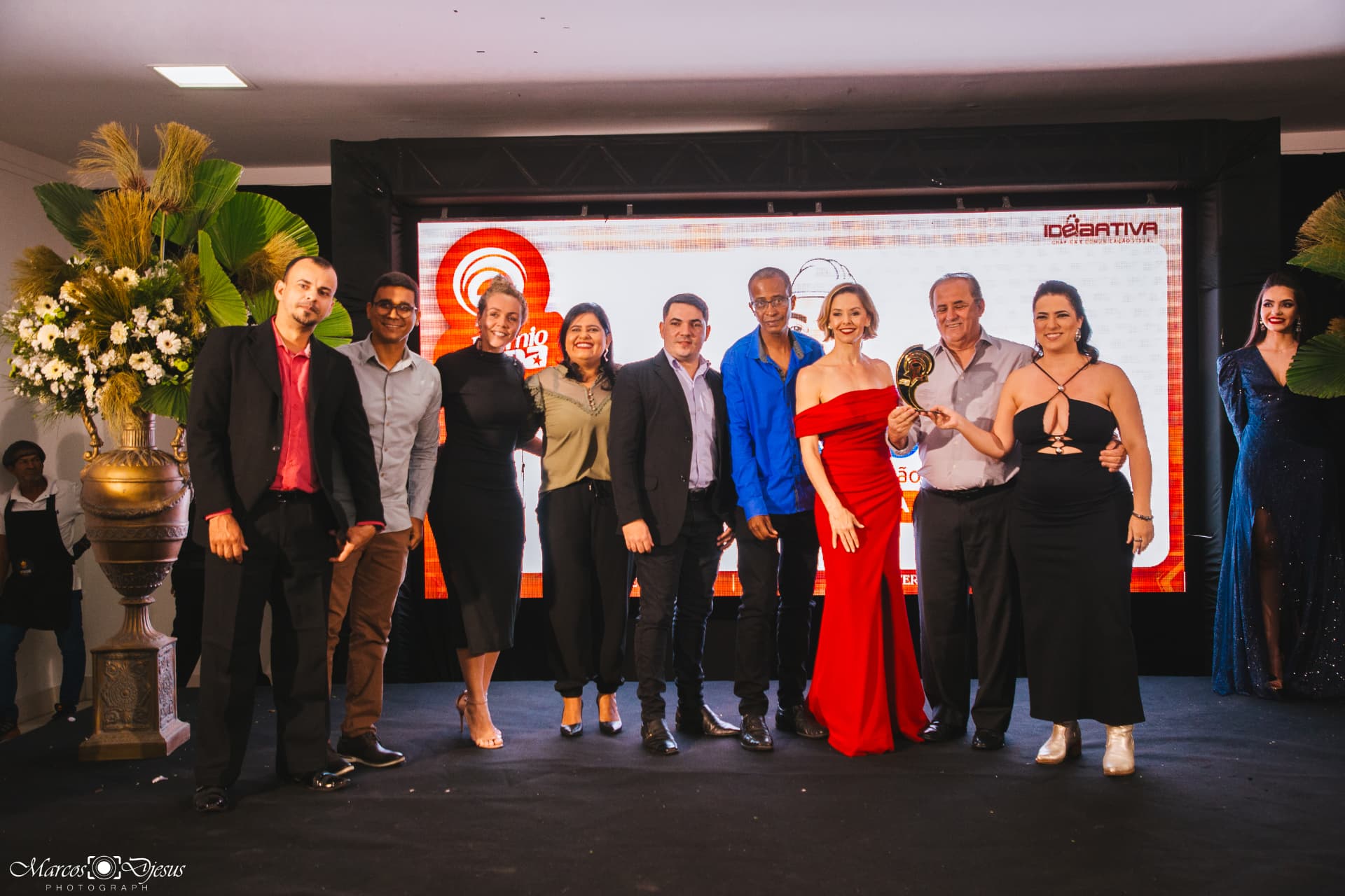 Grupo de dez pessoas posando para foto coletiva no palco do Prêmio Fama
